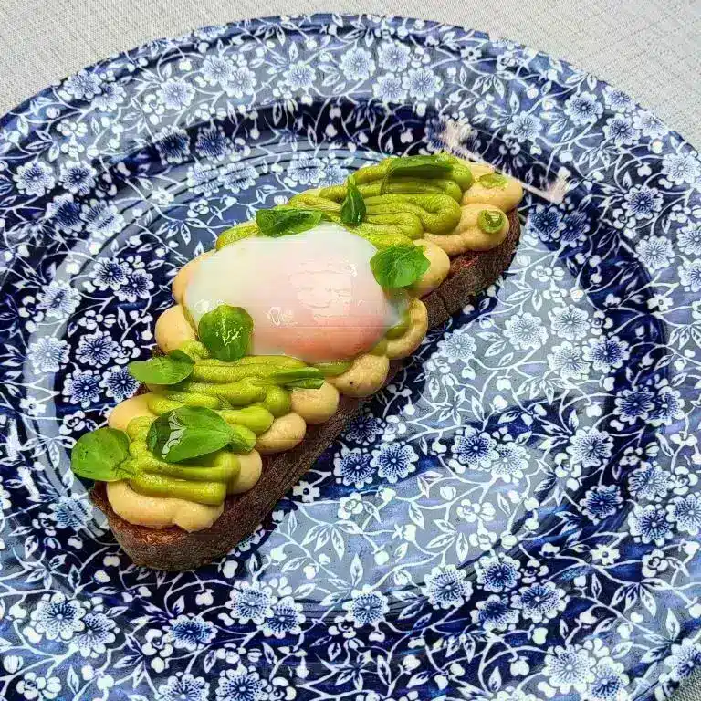 Imagen de una tosta de hummus, aguacate y huevo